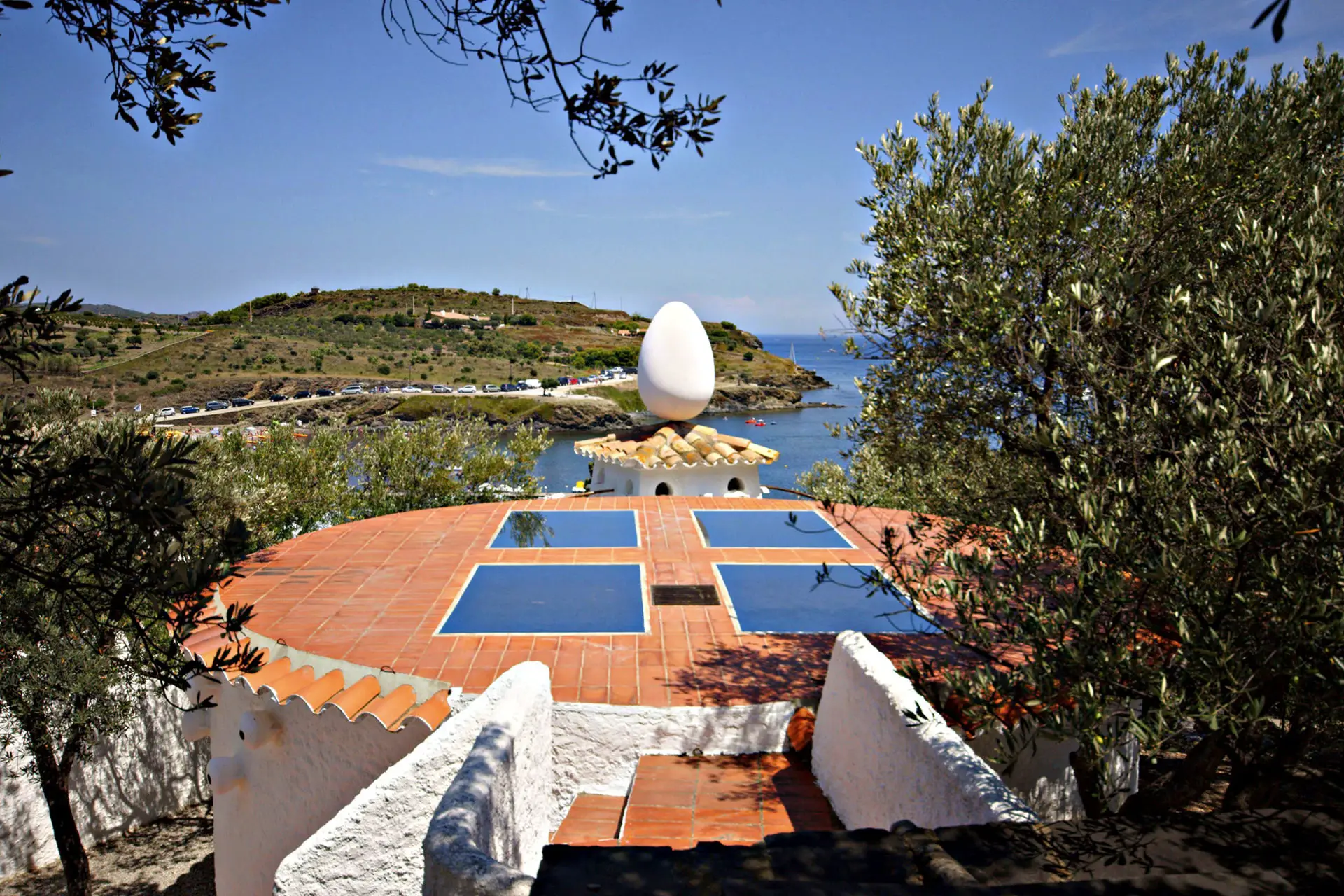 Back patio of Casa Salvador Dali with large egg statue overlooking the bay