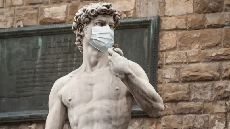 The Statue Of David in the Piazza della Signoria In Italy Wearing a Protective Face Mask
