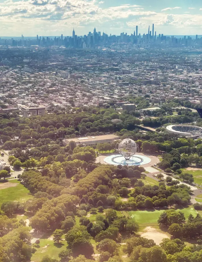 View from airplane window over the Queens site of the 1964 New York World’s Fair Unisphere with the Manhattan skyline in the background 
